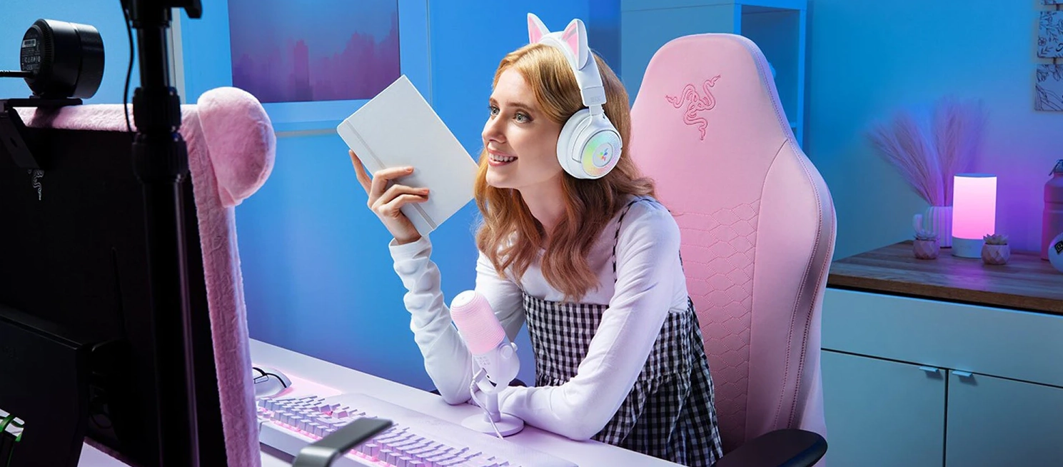 Slečna má nasazená bílá herní sluchátka Razer Kraken Kitty V3 Pro